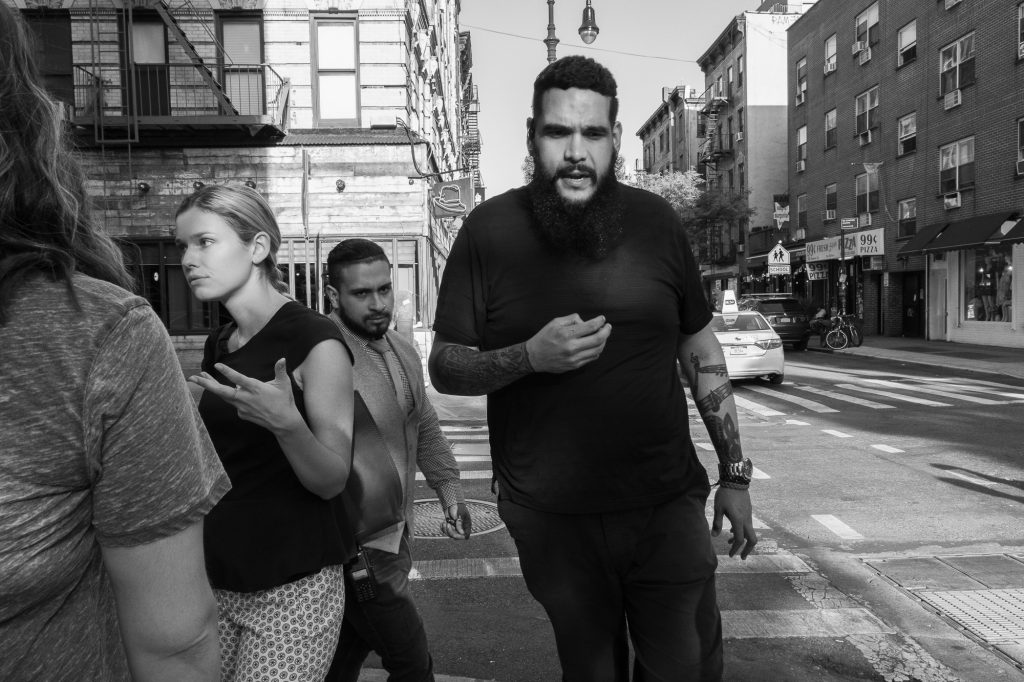 Learning to conquer your fear of street photography. two men walking down the street passing two women.