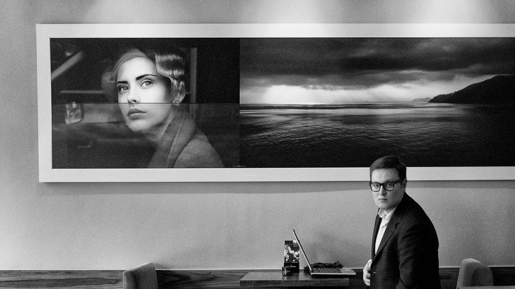 man sitting at table with picture above his head demonstrating fear of street photography