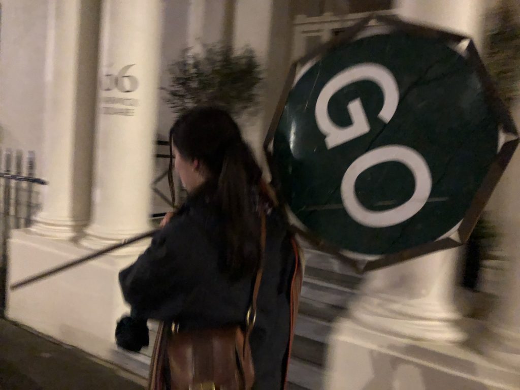 Girl walking down street with a balloon with words "go" printed on it