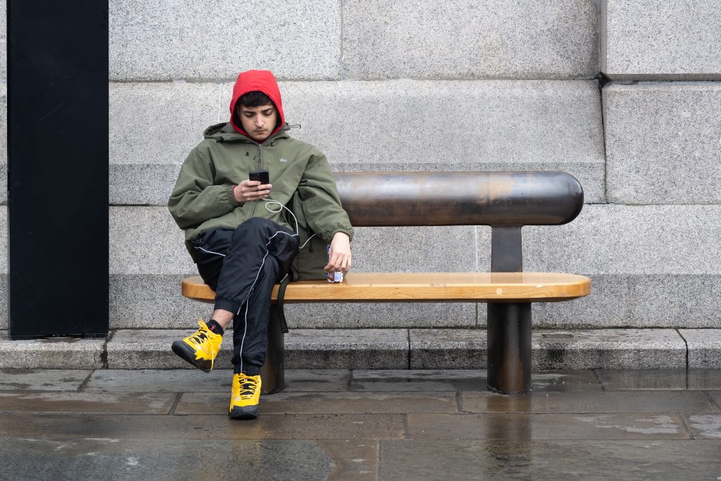 Man sitting in a red hat and yellow shoes. A collection of street photography articles